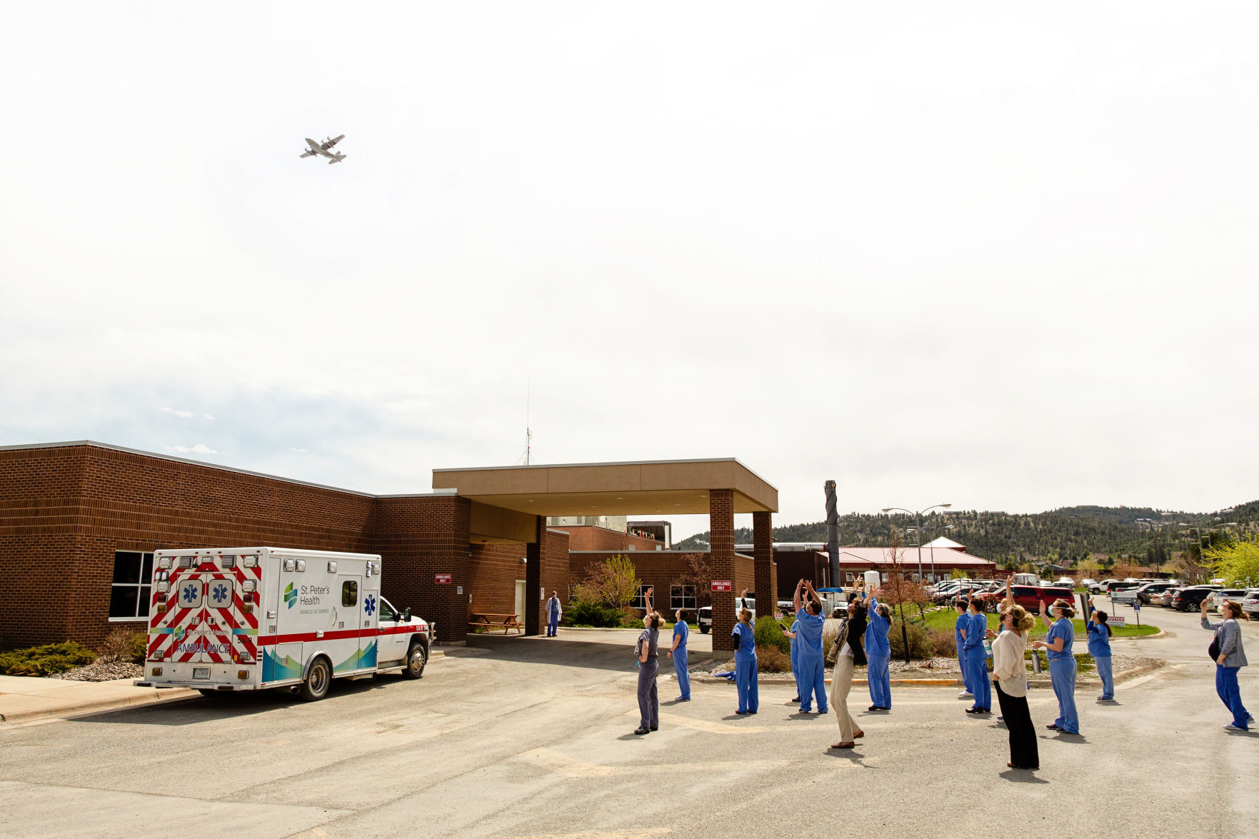 Nurses wave to a C-130 - May 2020